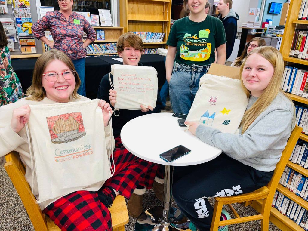 Teens decorate bags with representations of what community means to them.