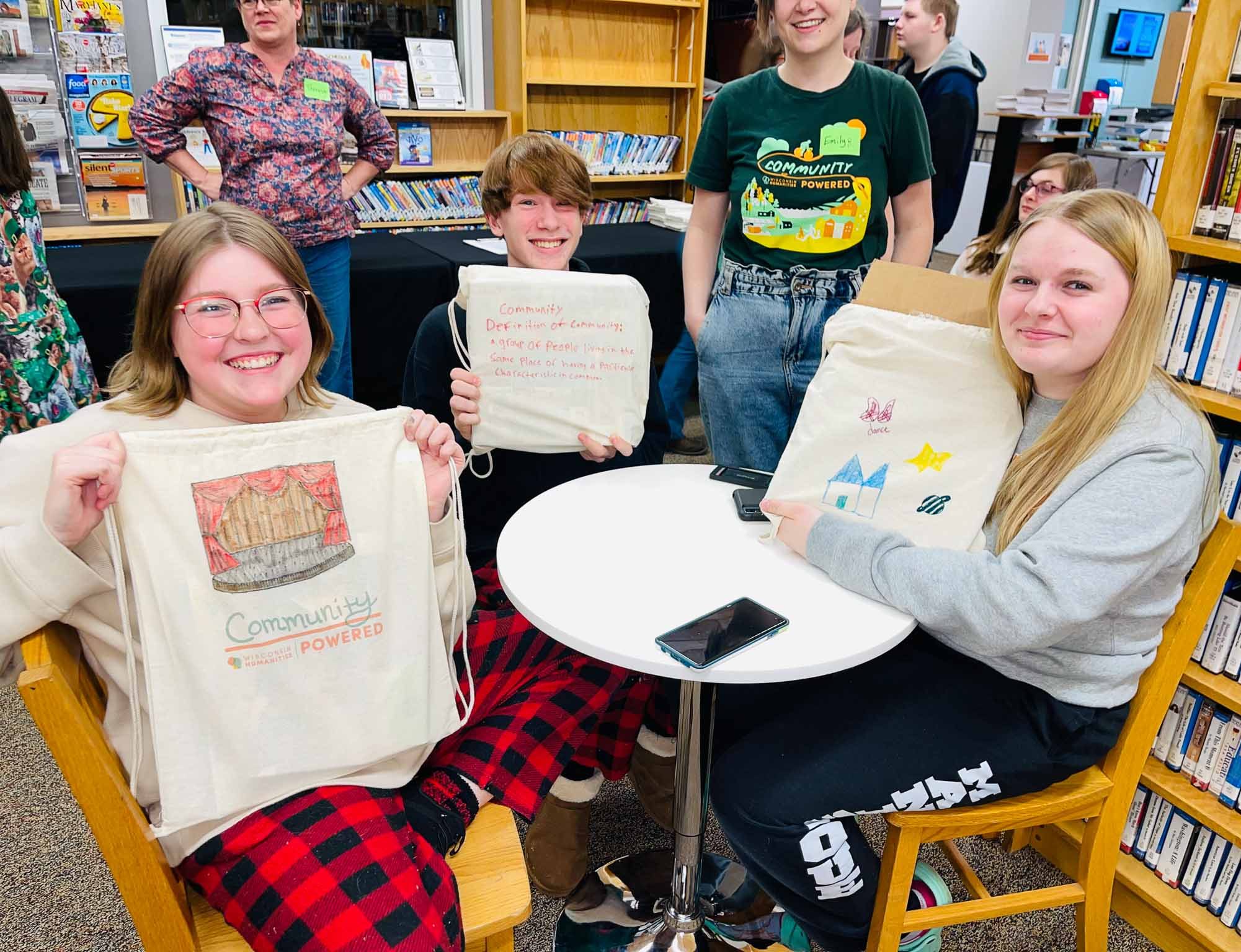 Teens decorate bags with representations of what community means to them.